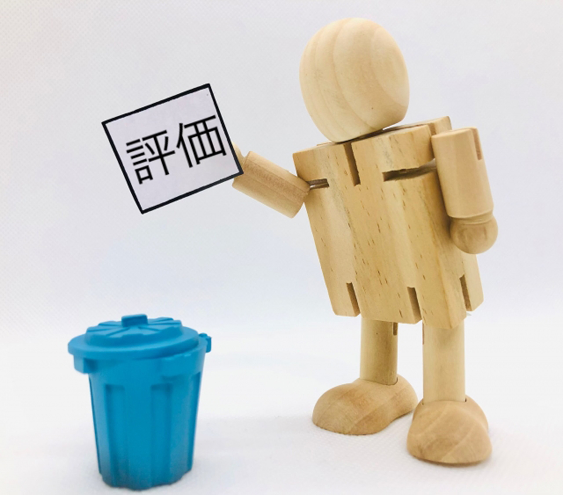 評価と書かれた紙をごみ箱に捨てる人