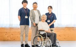 老人ホームにいるシニア夫婦と介護職員